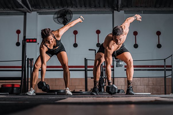 Closeup shot of an athletic male and female in the gym HIIT workout
