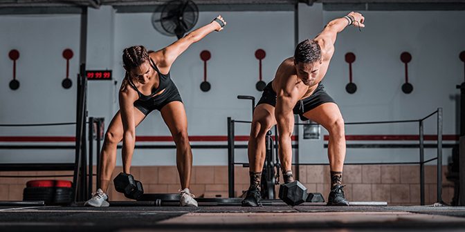 Closeup shot of an athletic male and female in the gym HIIT workout